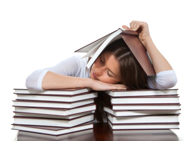 young girl student lying on the table tired sleeping books